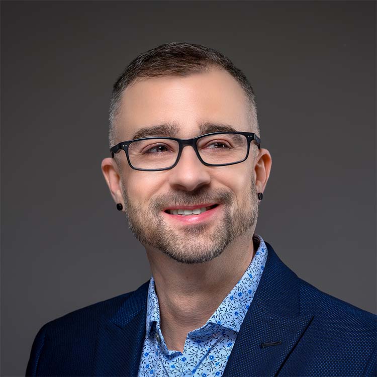 Professional photo of Zac Winner in blue suit on gray gradient background